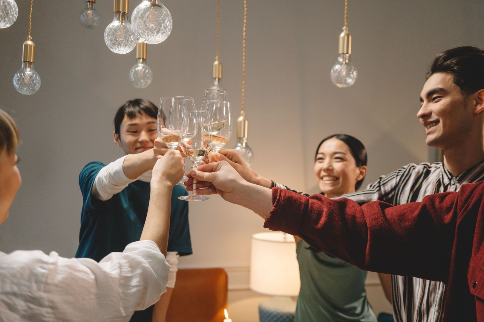 Friends raise wine glasses during a warmly lit reception